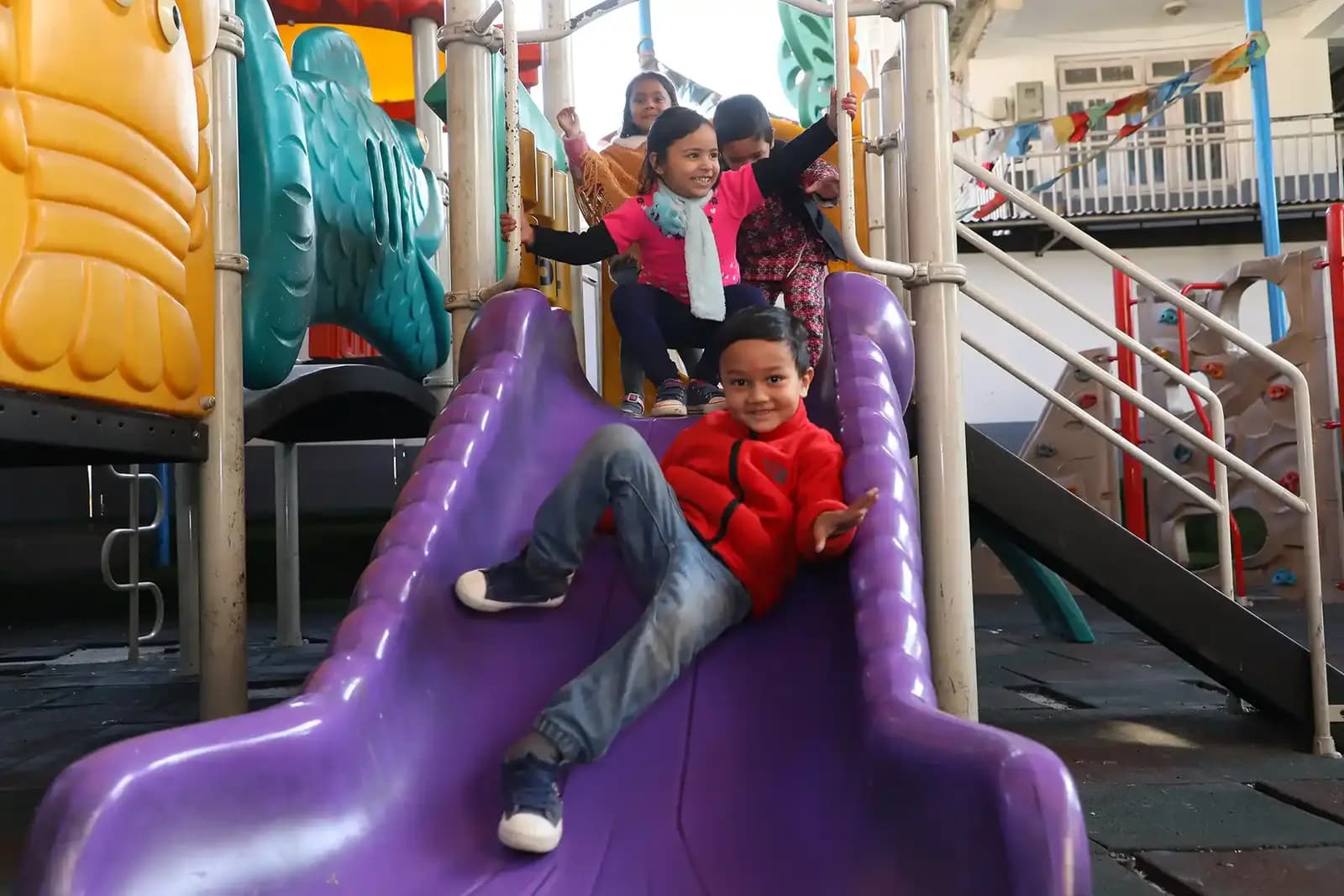 A child coming down the playground slide