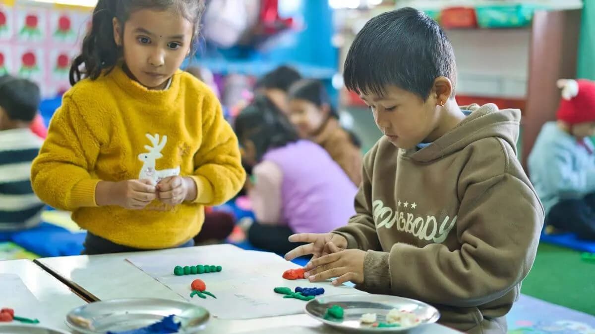 Two children shaping clay