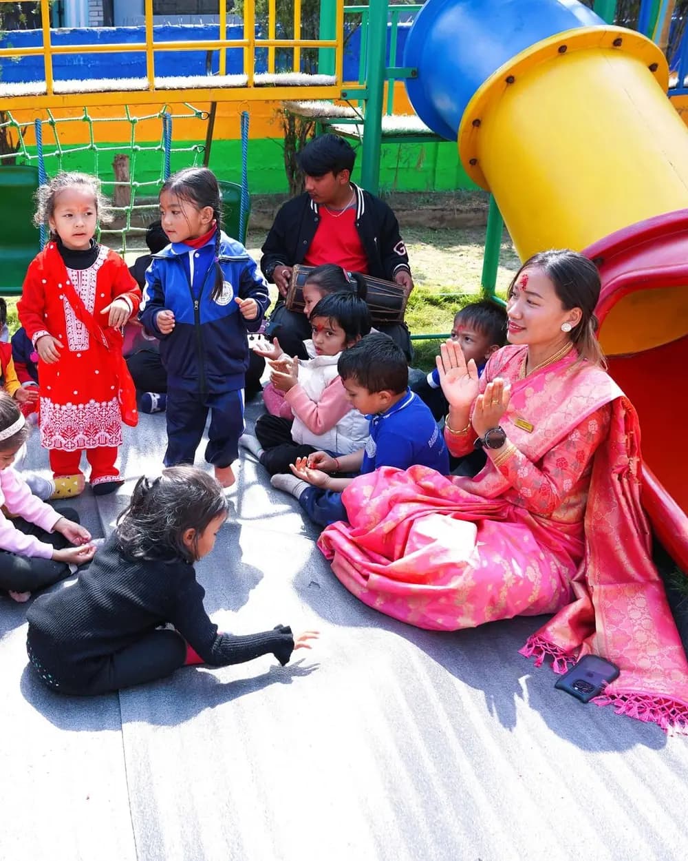 A teacher clapping along with toddlers