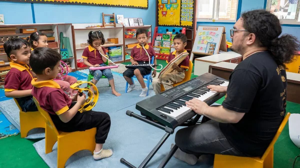 Children playing melodicas with their teacher