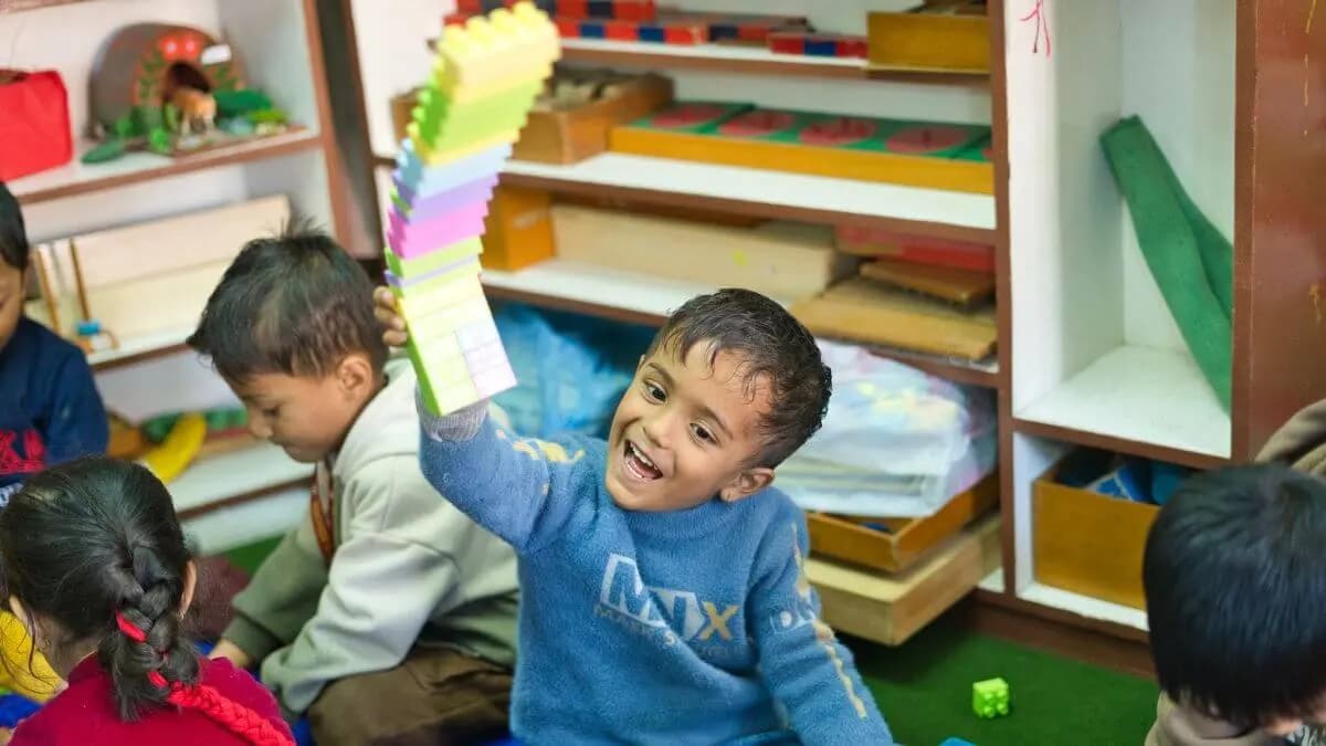 A child at the low classroom shelves